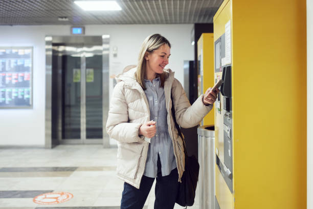 A woman uses a mobile phone for contactless payment in a vending machine